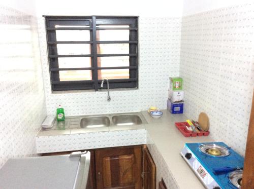 a small kitchen with a sink and a window at LES RÉSIDENCES SOHA in Cotonou