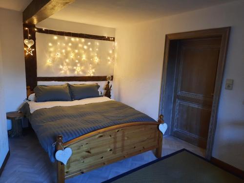 a bedroom with a bed with lights on the wall at Le Têli du loup in Stavelot