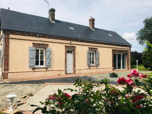 una casa vieja con ventanas y flores delante de ella en Gîte de la Perdrix, 