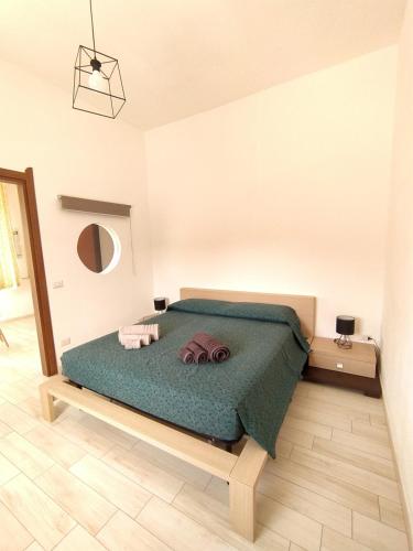 una camera con letto e piumone verde di Da Miky Casa Vacanze Teulada Sud Sardegna a Teulada