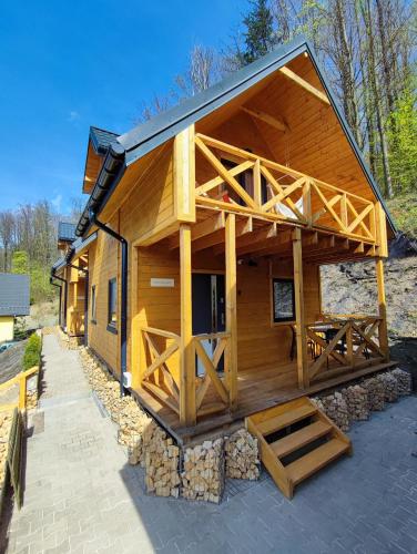 a large log cabin with a porch and a deck at Pokoje i Domki Na Szlaku in Polanica-Zdrój