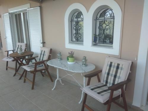 uma sala de jantar com uma mesa branca e cadeiras em Villa Katherine Laganas em Vanáton