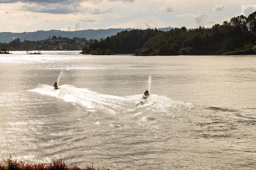 two people are water skiing on a lake at Hotel La Magdalena Adult Only in Guatapé