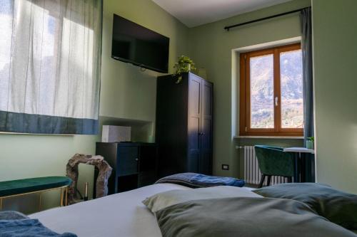 - une chambre avec 2 lits et une télévision murale dans l'établissement SulGarda Holiday Apartment, à Arco