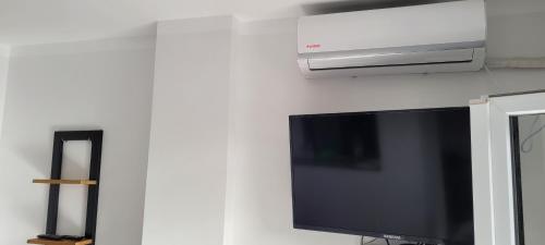 a flat screen tv hanging on a white wall at Immeuble THALA Tigzirt appart 90m2 in Tigzirt