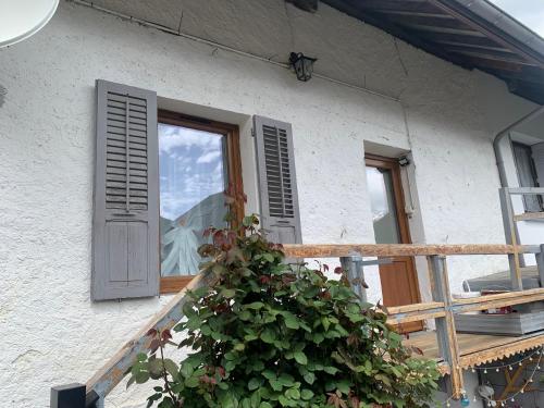 ein Fenster eines Hauses mit einer Pflanze davor in der Unterkunft Appartement cœur de maurienne 2 in Saint-Étienne-de-Cuines