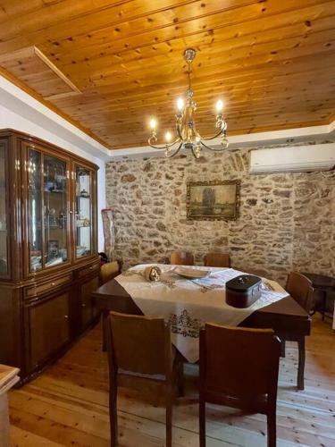 a dining room with a table and a stone wall at Πέτρινο εξοχικό στο Δάρα in Daras