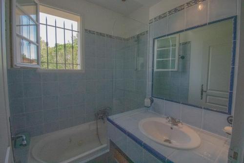 baño de azulejos azules con lavabo y bañera en Villa 80m² 3ch Piscine, en Fayence