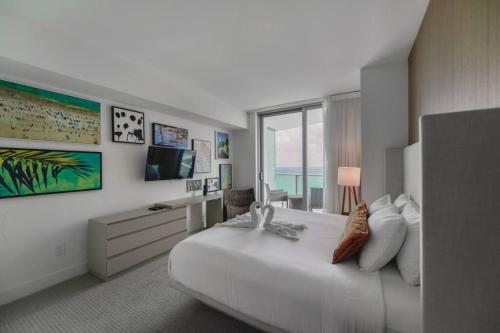 a hotel room with a large bed and a window at Gorgeous Views Await in Your Beachfront Condo in Hollywood