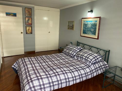 - une chambre avec un lit et une couverture en damier dans l'établissement CHARLIE'S HOUSE, à Bogotá