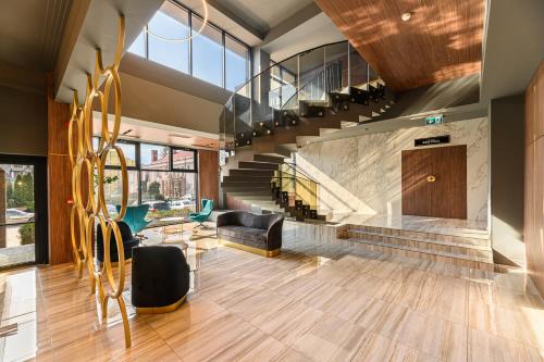 a lobby with a staircase and a living room at HOTEL CENTRAL Pascani in Paşcani
