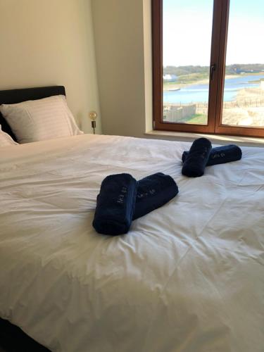 a bed with two pairs of blue towels on it at Lets Go Raversijde in Ostend