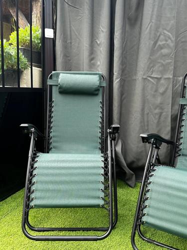 two chairs sitting on the grass in front of a window at LE WÜRM in Monnet-la-Ville
