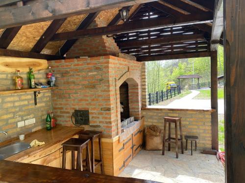 a kitchen with a brick oven with a table and chairs at Kuca za odmor Marjanovic in Gornji Milanovac