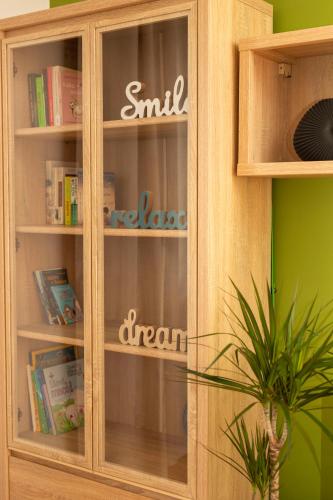 a wooden book shelf with a glass door at Downtown Labin in Labin