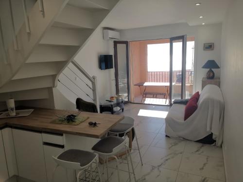 - un salon avec un escalier, une table et des chaises dans l'établissement La baie d'Agay, à Saint-Raphaël