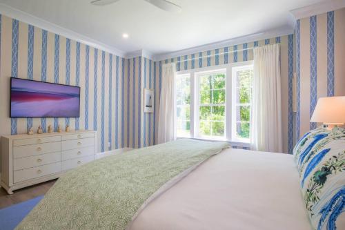 a bedroom with a bed and a tv on a wall at Whispering Palms in Seabrook Island