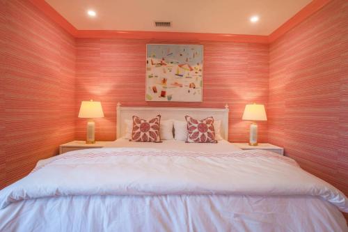 a bedroom with a large white bed with two lamps at Whispering Palms in Seabrook Island