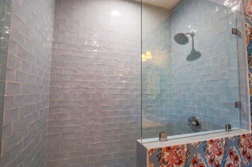a bathroom with a shower with blue tiles at Whispering Palms in Seabrook Island
