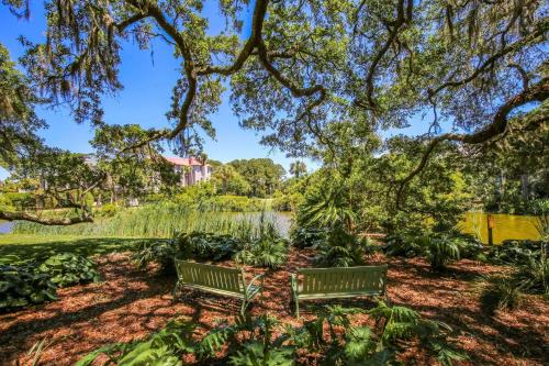 two benches under a tree in a park at Whispering Palms in Seabrook Island