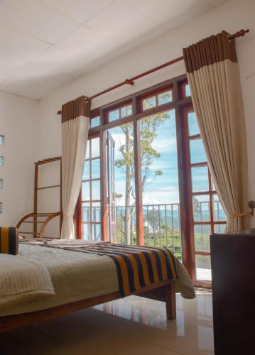 a bedroom with a bed and a large window at Hillcrest Haputale in Haputale