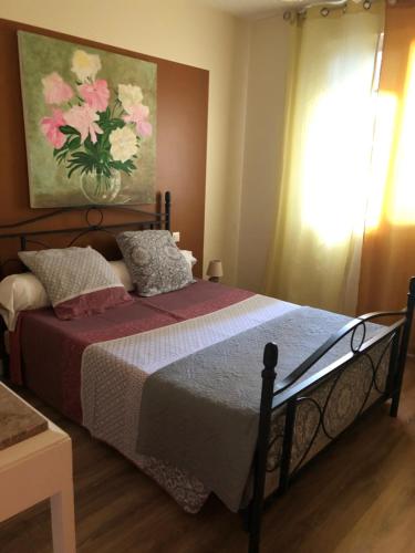 une chambre avec un lit avec un tableau sur le mur dans l'établissement La Cabanes, à Senouillac