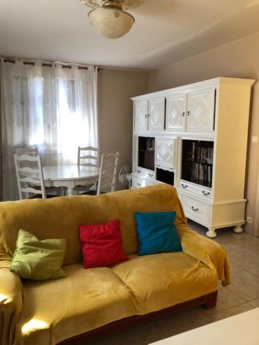 - un salon avec un canapé et quatre oreillers colorés dans l'établissement La Cabanes, à Senouillac