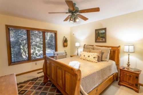 Un dormitorio con una cama y un ventilador de techo. en Creekside at Yonahlossee, en Blowing Rock