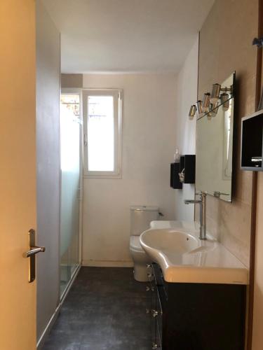 une salle de bain avec un lavabo et des toilettes et une fenêtre dans l'établissement La Cabanes, à Senouillac