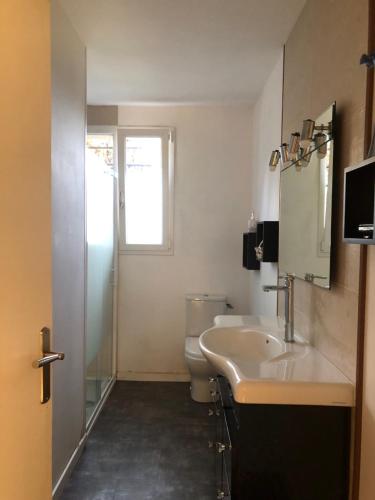 SenouillacにあるLa Cabanesのバスルーム(洗面台、トイレ付)、窓が備わります。