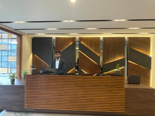 a man standing at a reception desk in an office at Royal Ace Boutique Hotel - Manyata Techpark in Bengaluru
