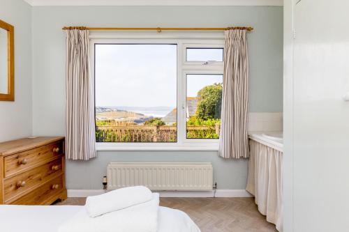 a bedroom with a window and a radiator at Bella Vista in Polzeath