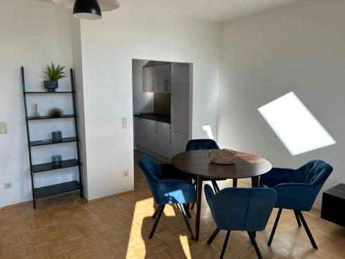 a dining room with a table and blue chairs at Gamlitz - RaStra Top 20 in Gamlitz