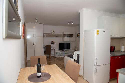 eine Küche und ein Wohnzimmer mit einem Tisch und einem Kühlschrank in der Unterkunft Apartment Fortuna - peacfull terrace in Klis