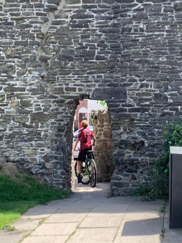 uma pessoa a andar de bicicleta através de uma parede de pedra em 3 Newboro Terrace, Conwy em Conwy