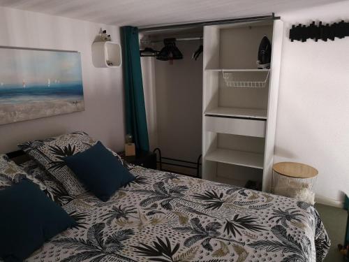 een kleine slaapkamer met een bed en een kast bij Studio mezzanine vue mer in Cavalaire-sur-Mer