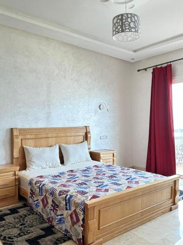a bedroom with a bed and a red curtain at Nice Apartment in Marina Agadir in Agadir
