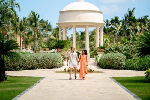 a couple walking through the gardens of a resort at Jewel Punta Cana All-Inclusive Resort in Punta Cana