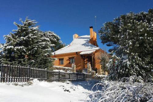a house covered in snow with a fence and trees at Via Fera, con vistas a la naturaleza in Braojos de la Sierra