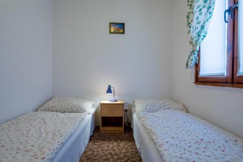 two twin beds in a room with a window at DOMKI LUNA in Rowy