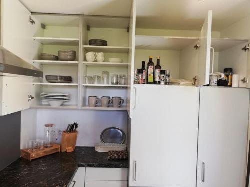 a kitchen with white cabinets and bottles of wine at Urlaub in Alberschwende in Alberschwende