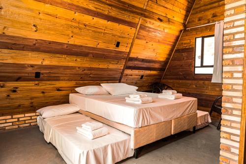 two beds in a room with wooden walls at Pousada Al Mare Beach in Luis Correia