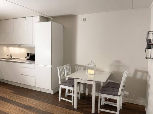 a kitchen with a table and chairs and a refrigerator at City Center Royal Pallace in Oslo