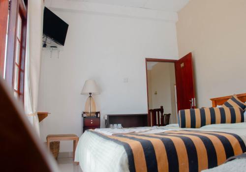 a bedroom with a bed and a chair and a mirror at Hillcrest Haputale in Haputale