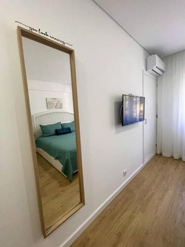 a mirror in a room with a bed in it at Solbelo Quarteira Beach in Quarteira