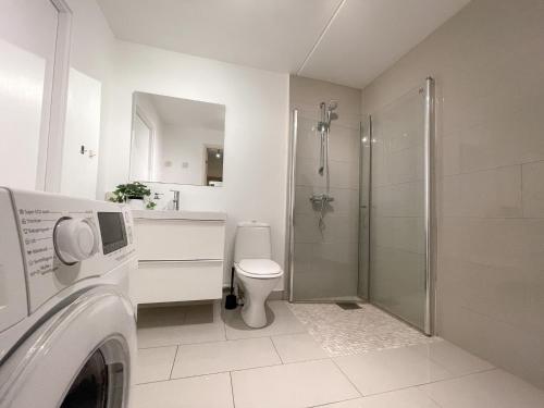 a white bathroom with a toilet and a shower at City Center Royal Pallace in Oslo