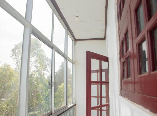 an empty room with a window and a red door at Hillcrest Haputale in Haputale