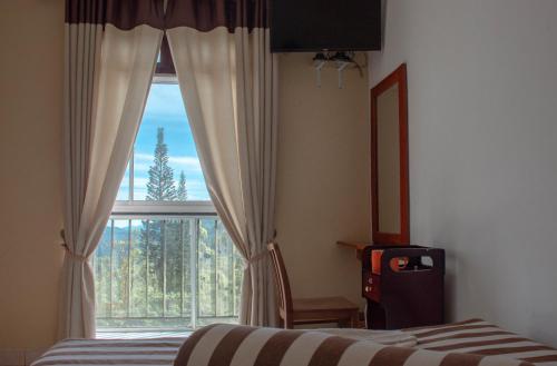 a bedroom with a bed and a large window at Hillcrest Haputale in Haputale