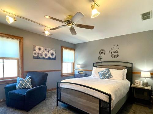 a bedroom with a bed and a ceiling fan and a chair at Riverboat Suites in Galena