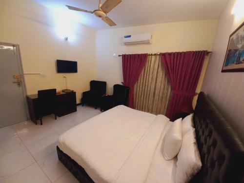 a hotel room with a bed and a tv at Travel Inn islamabad in Islamabad